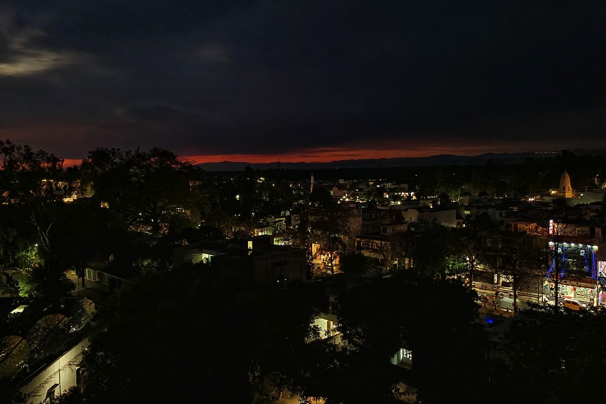 Aerial view of a hillside town glowing with lights after sunset