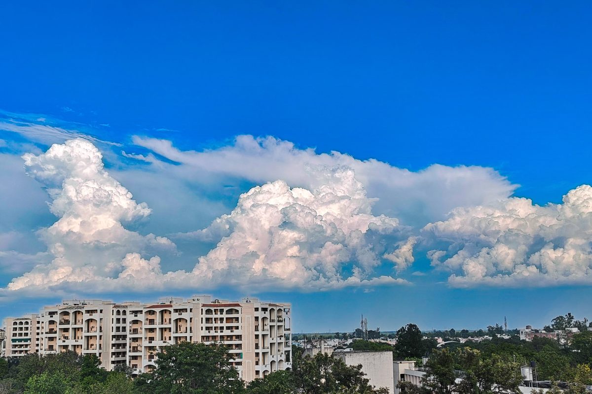 Apartment skyline beneath dramatic clouds against a deep blue sky